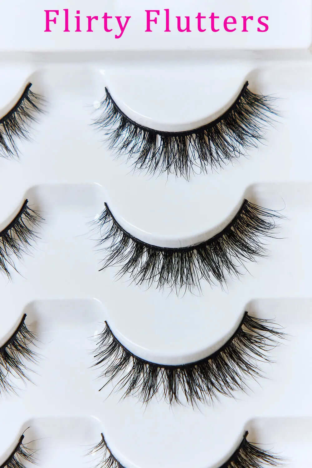 Flirty Flutters Mink Eyelashes collection showcasing four luxurious pairs on a display.