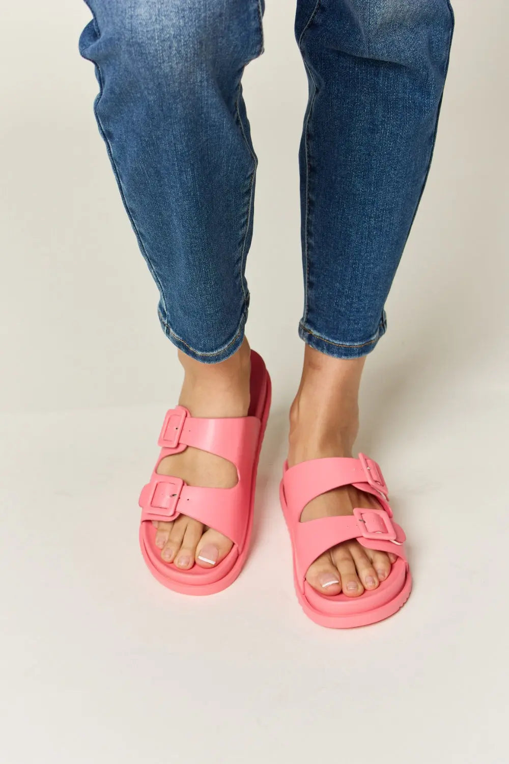 Legend Double Buckle Open Toe Sandals in pink worn with denim, showcasing trendy design and adjustable fit.