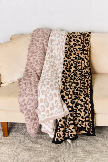 Cuddley Leopard Decorative Throw Blanket in various colors draped over a couch, showcasing cozy leopard print design.